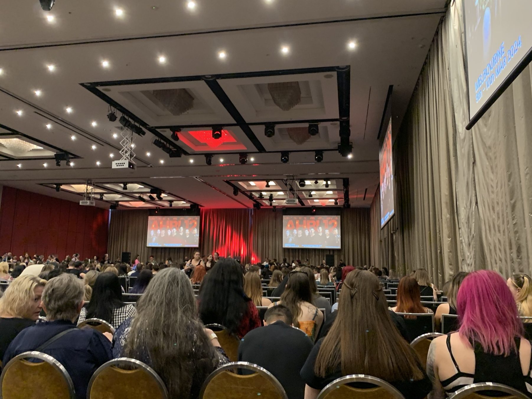 Many people sitting in front of a stage