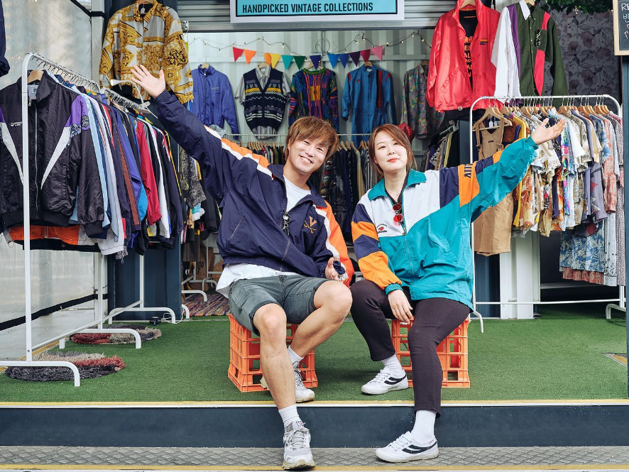 People Posing in front of their clothing stall