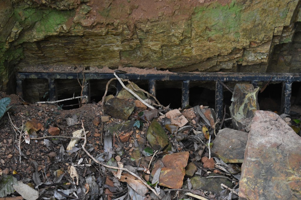 old mine opening covered by dirt and rubble