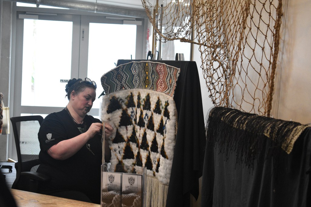 Māori woman weaving traditional dress