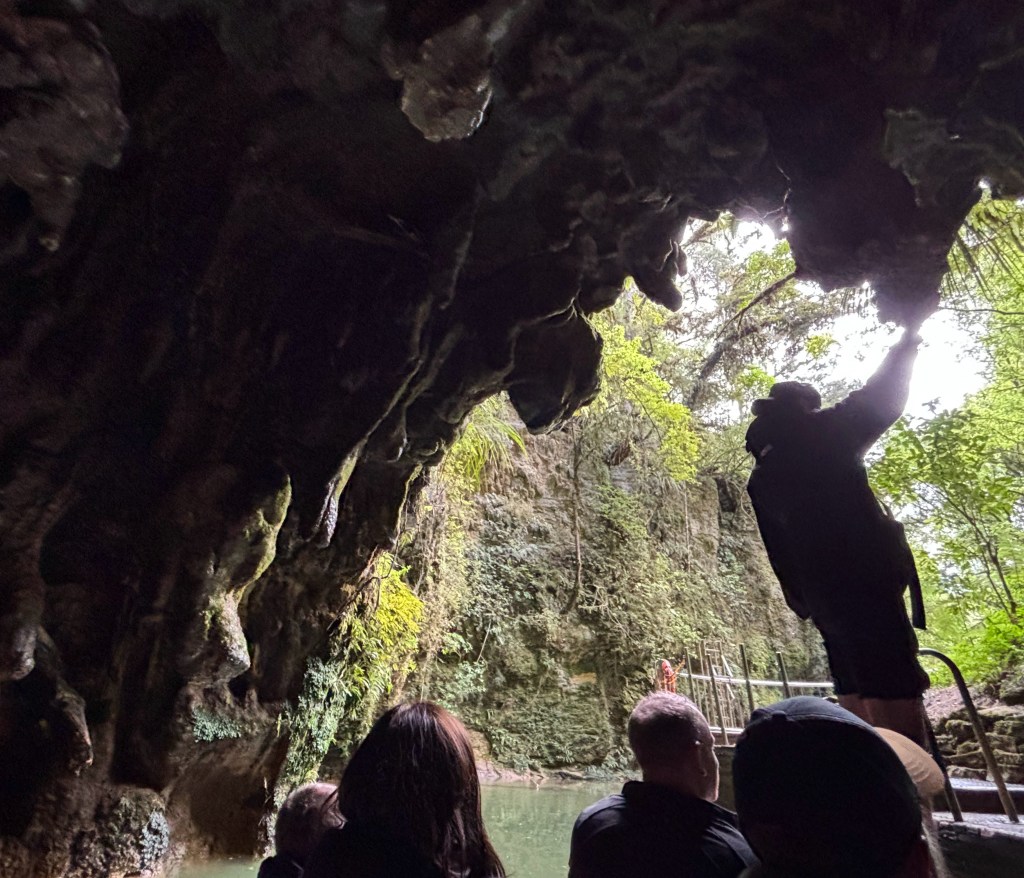 people in boat at cave opening