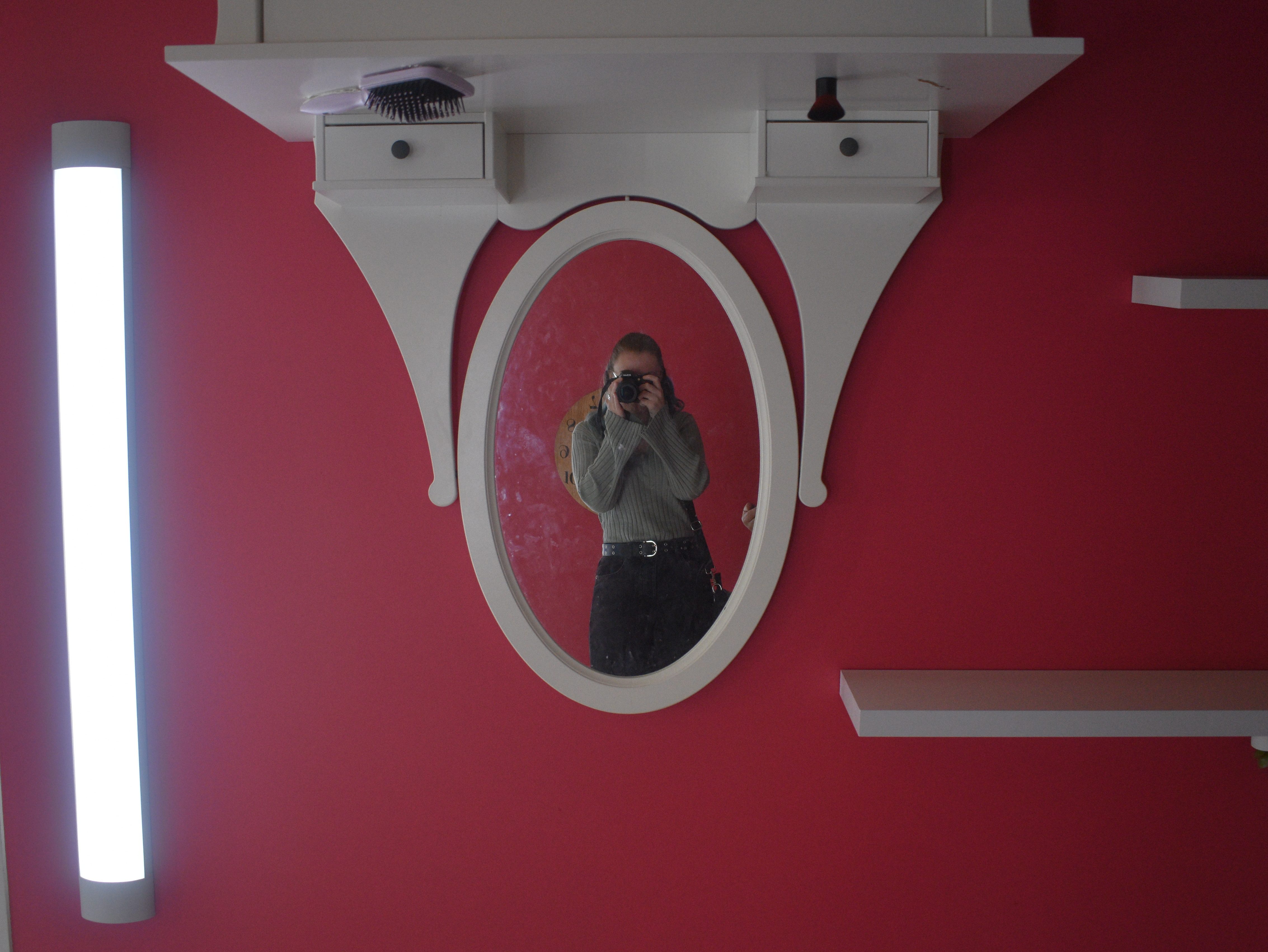 person taking photo in an upside down mirror