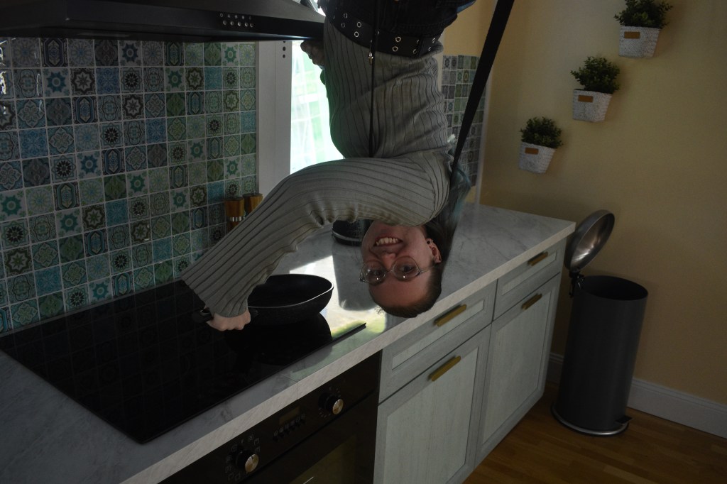 person upside down cooking on kitchen stove