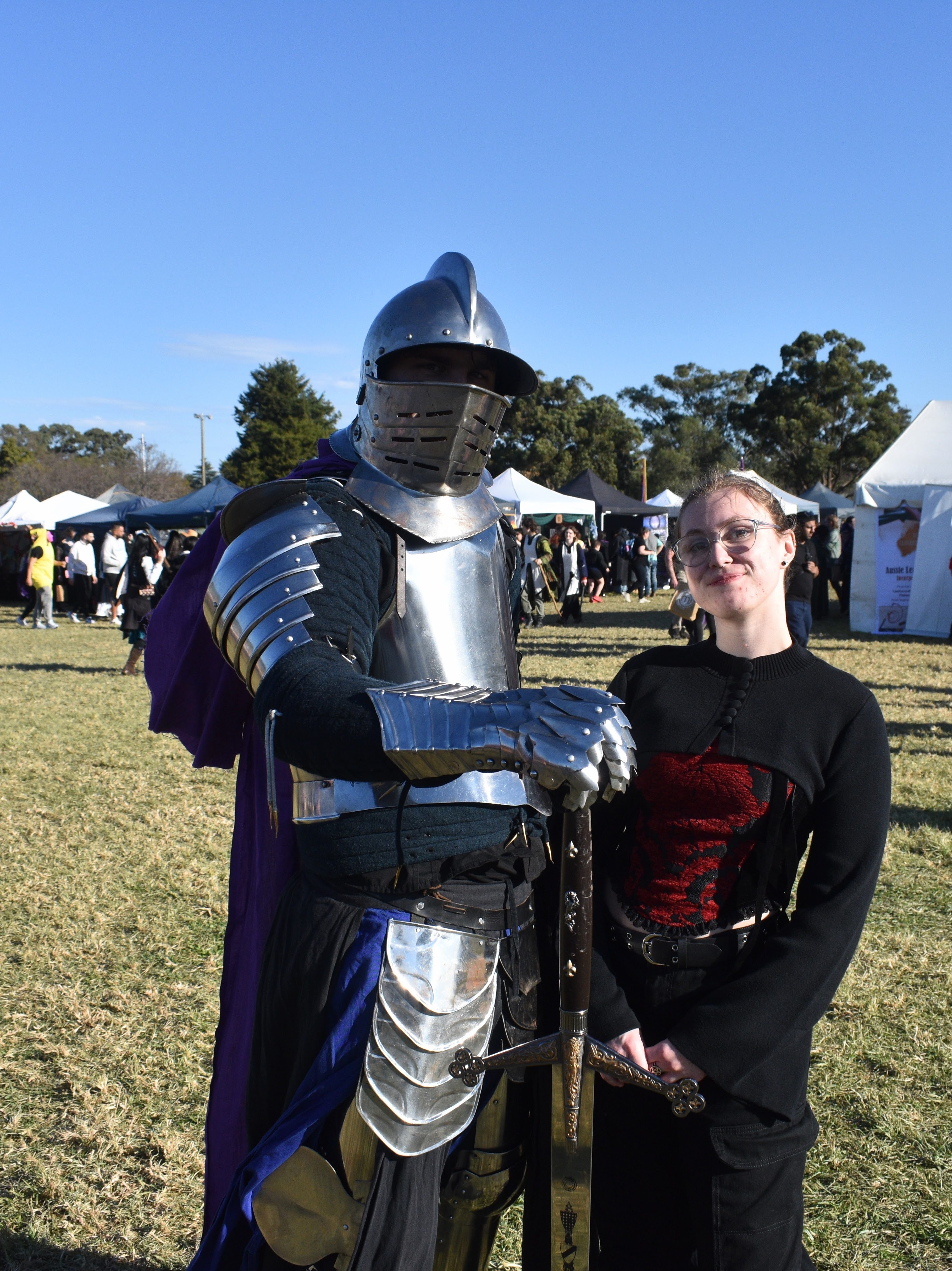 author standing next to knight in medieval dress
